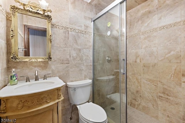 bathroom featuring vanity, toilet, tile walls, and walk in shower