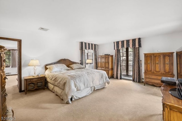 bedroom with a baseboard radiator and light colored carpet