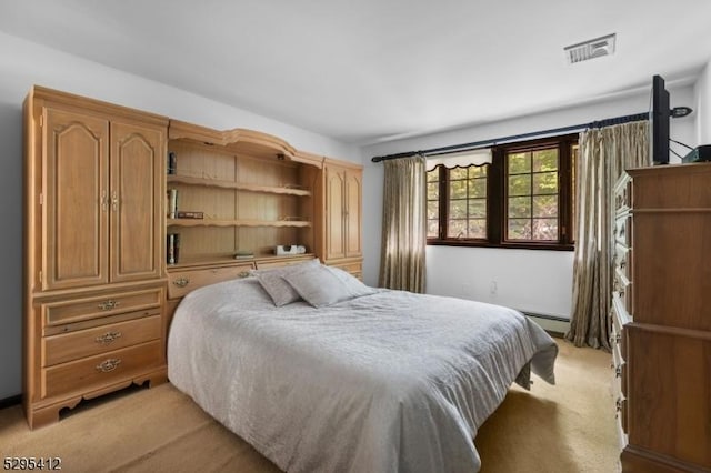 bedroom with light carpet and a baseboard heating unit