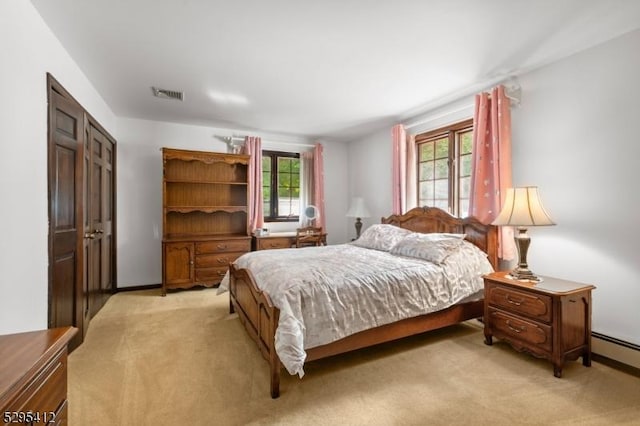 bedroom featuring light carpet and a baseboard radiator