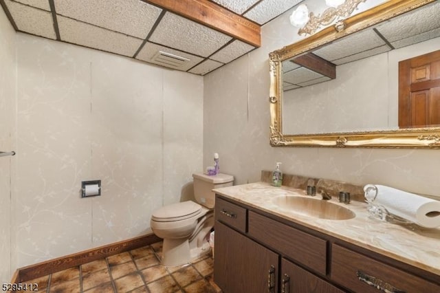 bathroom with vanity, a paneled ceiling, and toilet