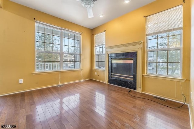 unfurnished living room featuring ceiling fan and hardwood / wood-style floors