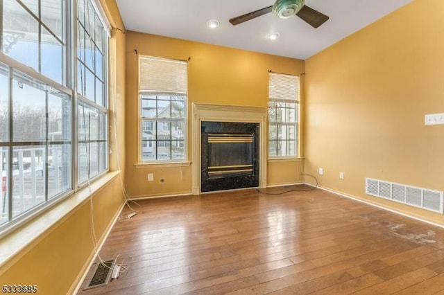 unfurnished living room featuring wood-type flooring and ceiling fan