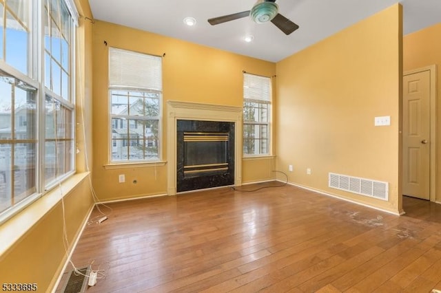 unfurnished living room featuring ceiling fan and hardwood / wood-style floors