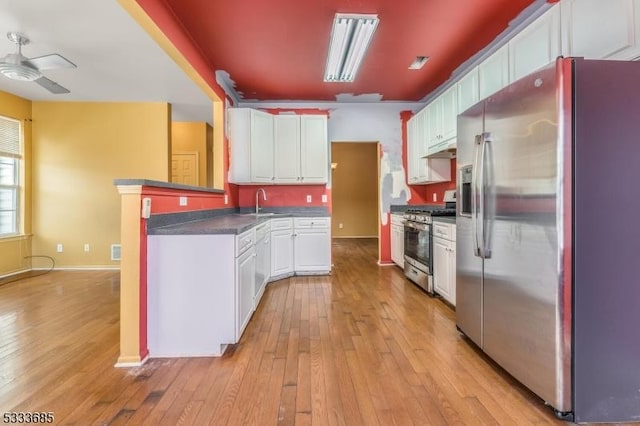 kitchen with light hardwood / wood-style flooring, ceiling fan, appliances with stainless steel finishes, sink, and white cabinets