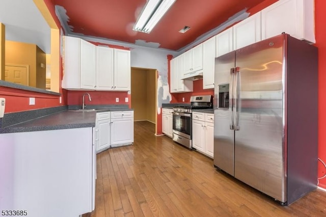 kitchen with sink, white cabinets, light hardwood / wood-style flooring, and stainless steel appliances