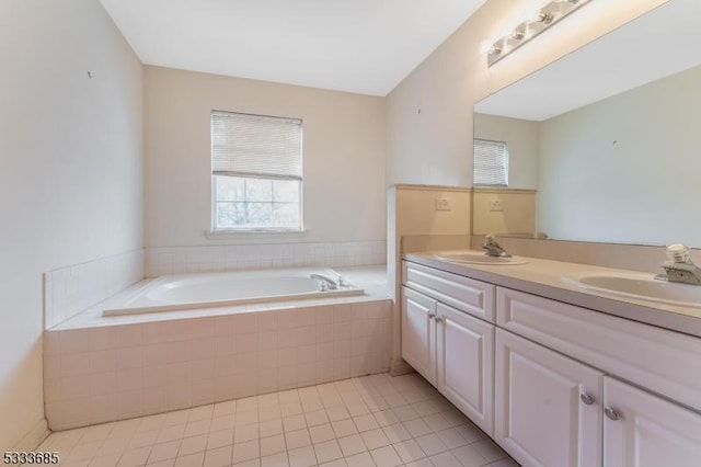 bathroom featuring tile patterned floors, a relaxing tiled tub, and vanity