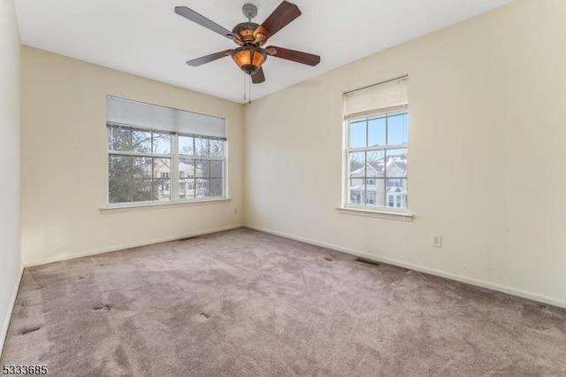 empty room featuring ceiling fan and light colored carpet