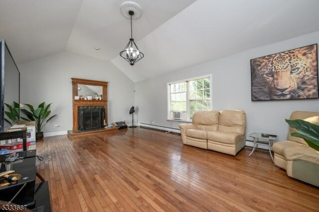 living room featuring lofted ceiling, hardwood / wood-style flooring, a premium fireplace, a baseboard heating unit, and a chandelier