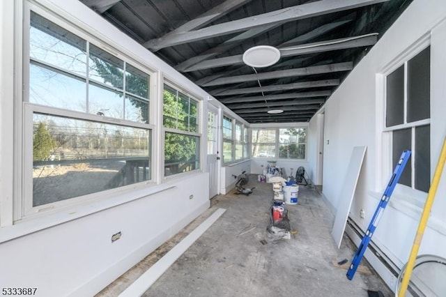 unfurnished sunroom featuring a healthy amount of sunlight and a baseboard heating unit