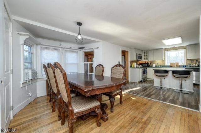 dining room featuring cooling unit and light hardwood / wood-style floors