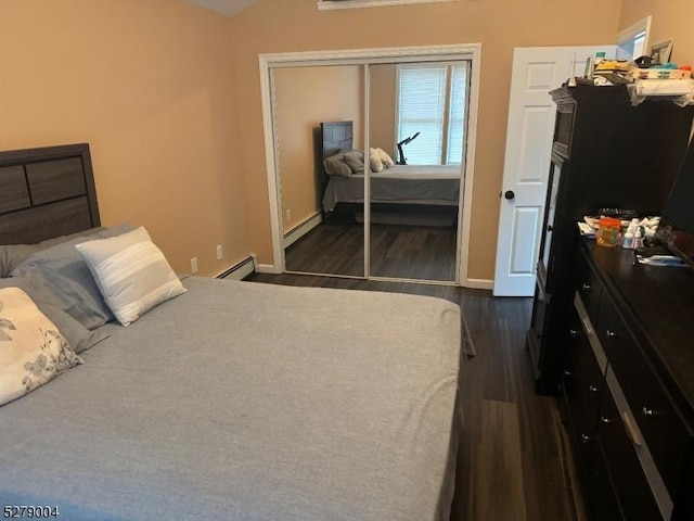 bedroom featuring baseboard heating, a closet, and dark hardwood / wood-style floors