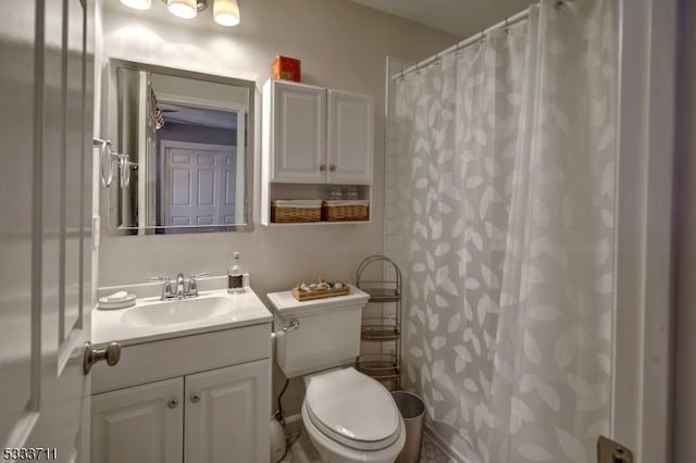 bathroom with toilet, vanity, and curtained shower