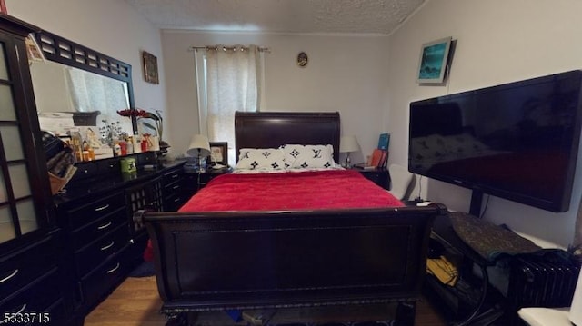 bedroom with hardwood / wood-style flooring, a textured ceiling, and lofted ceiling