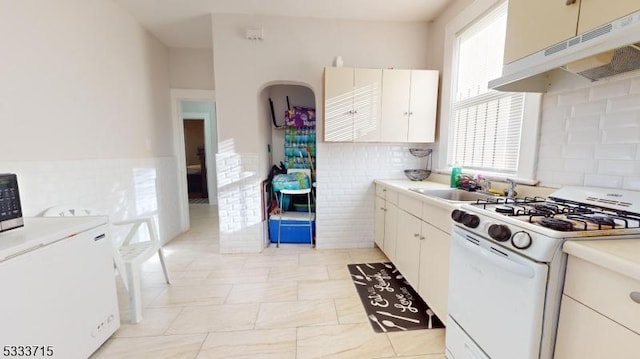 kitchen featuring white cabinets, sink, and white range with gas cooktop