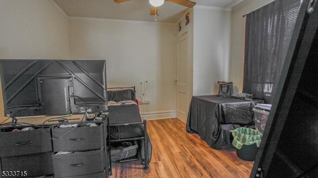 home office featuring ceiling fan, wood-type flooring, and ornamental molding