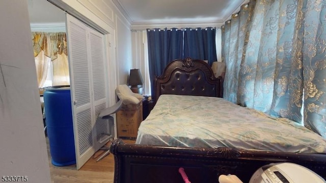 bedroom featuring hardwood / wood-style floors, a closet, and ornamental molding