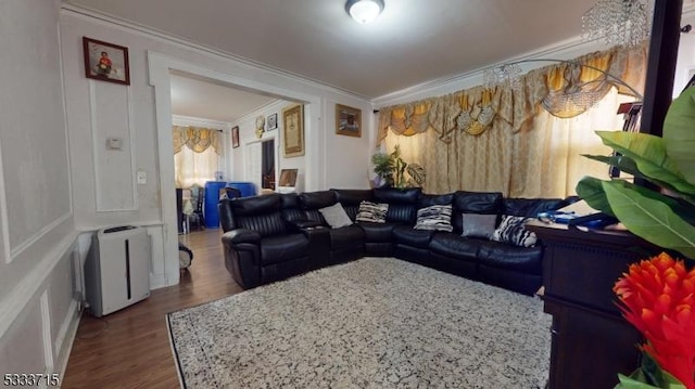 living room featuring dark wood-type flooring and ornamental molding