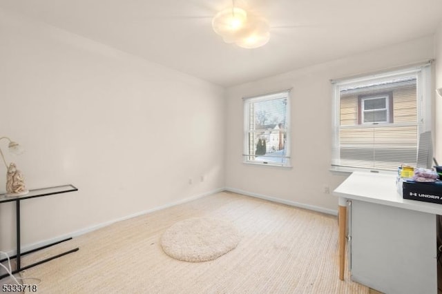 home office with light carpet and baseboards