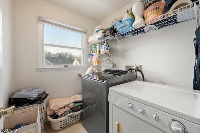 clothes washing area featuring laundry area and washer and clothes dryer