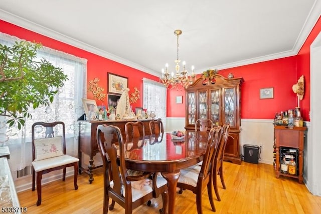 dining space featuring a chandelier, crown molding, and light wood-style flooring