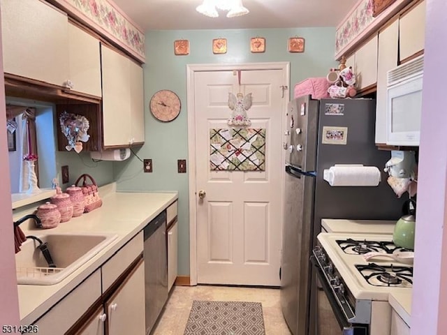 kitchen with white cabinetry, sink, and white appliances