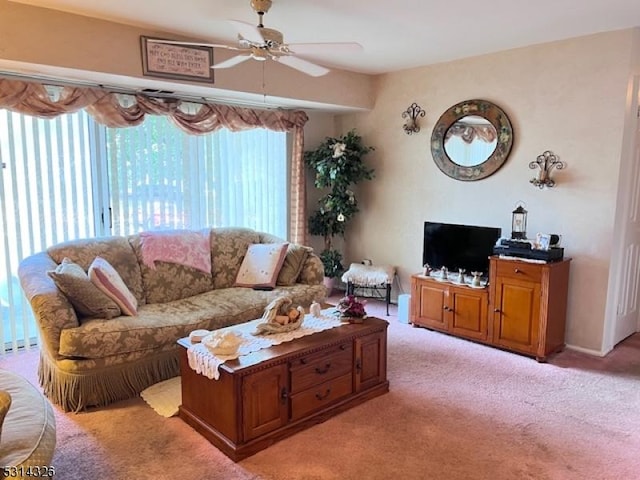 carpeted living room with ceiling fan and a healthy amount of sunlight