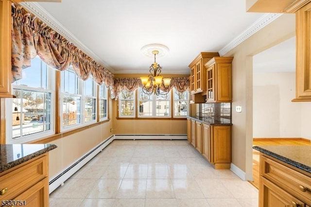 kitchen with dark stone countertops, a notable chandelier, ornamental molding, and baseboard heating