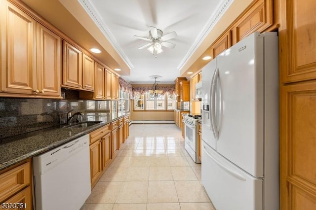 kitchen featuring sink, crown molding, decorative light fixtures, white appliances, and dark stone counters