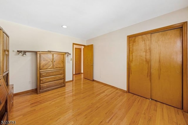 unfurnished bedroom featuring light hardwood / wood-style floors and a closet