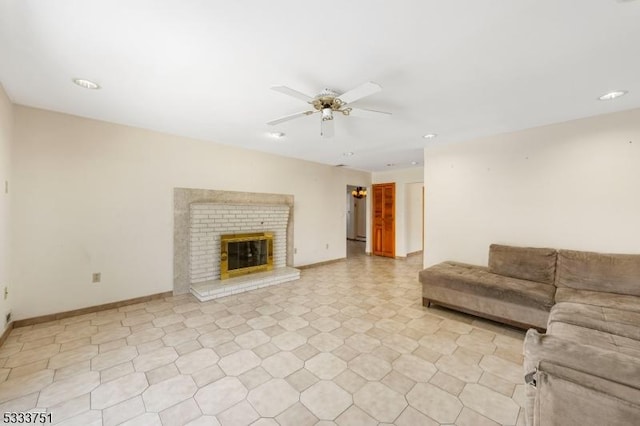 unfurnished living room featuring ceiling fan and a brick fireplace