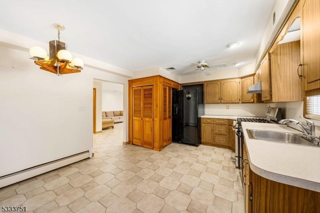 kitchen featuring ceiling fan with notable chandelier, baseboard heating, black fridge with ice dispenser, stainless steel range with gas cooktop, and decorative light fixtures