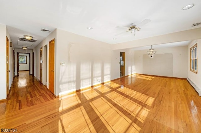 spare room with a baseboard radiator, ceiling fan with notable chandelier, and hardwood / wood-style floors