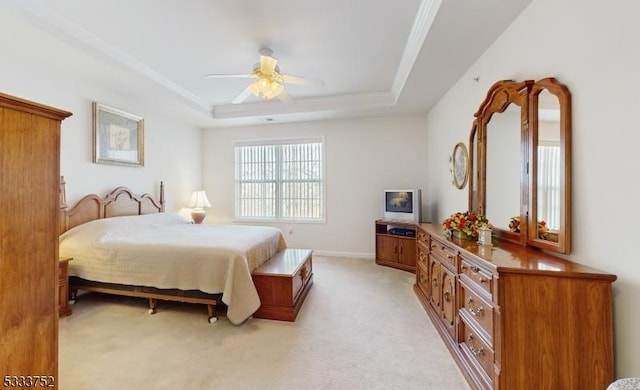 carpeted bedroom featuring a raised ceiling and ceiling fan