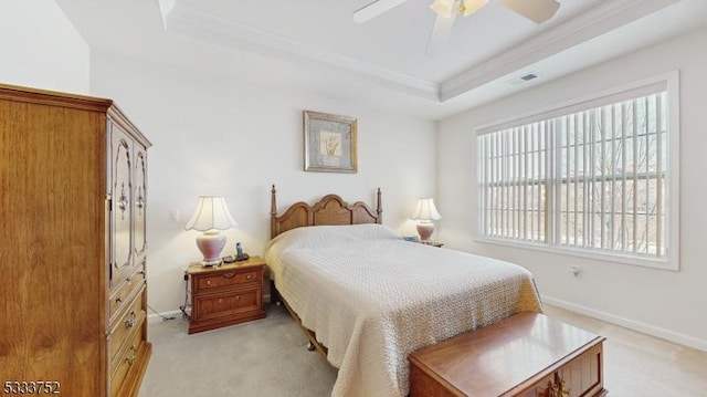 carpeted bedroom with a tray ceiling and ceiling fan