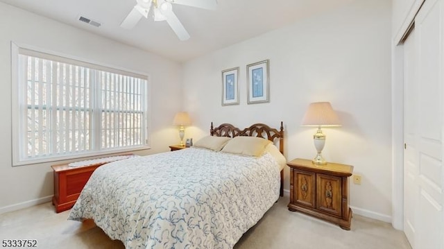 bedroom featuring ceiling fan, light colored carpet, and a closet