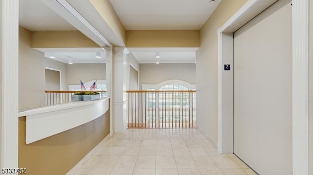 hallway with light tile patterned flooring and elevator