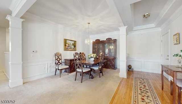 dining space with ornate columns, ornamental molding, and hardwood / wood-style floors