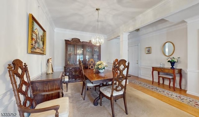 dining space with ornate columns, crown molding, and a chandelier