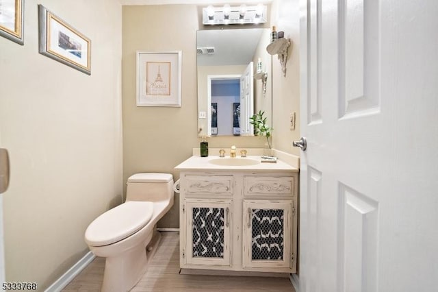 bathroom with vanity, toilet, and hardwood / wood-style floors