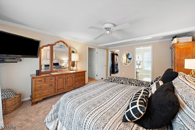 bedroom with light carpet, ceiling fan, ensuite bath, a walk in closet, and a closet