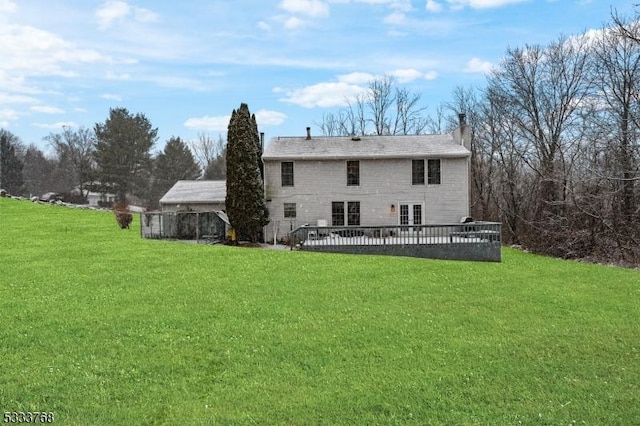 back of house with a deck and a lawn