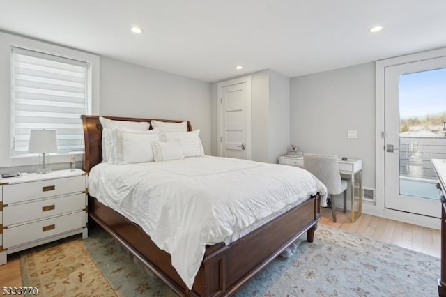 bedroom featuring light hardwood / wood-style floors, access to outside, and multiple windows