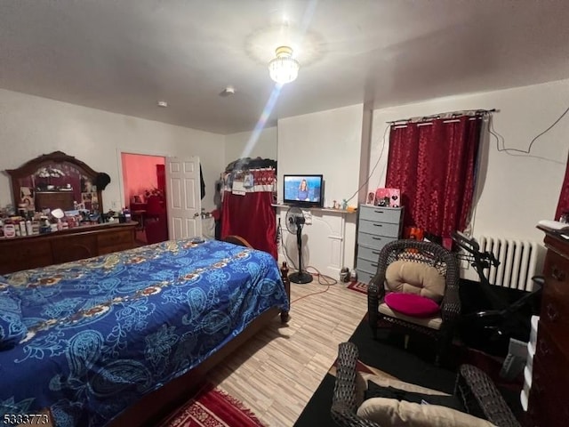 bedroom featuring wood-type flooring and radiator heating unit