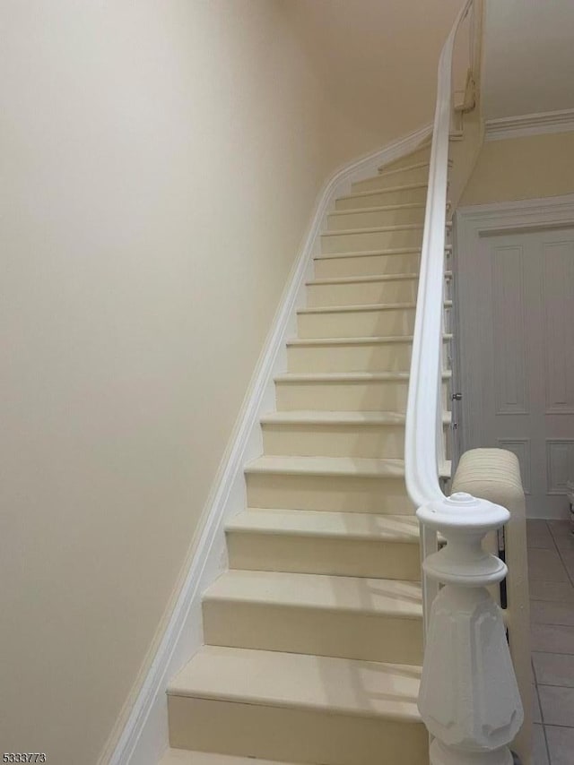 stairs featuring tile patterned flooring and ornamental molding