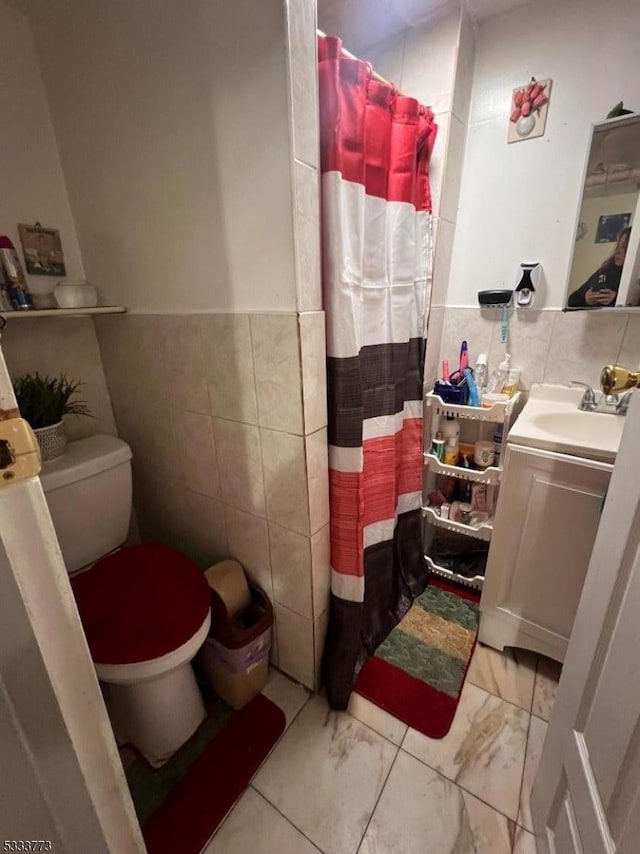 bathroom featuring curtained shower, toilet, vanity, and tile walls