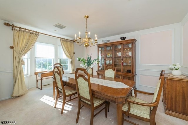 dining space with an inviting chandelier and light colored carpet