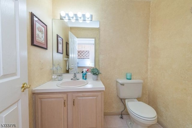 bathroom featuring tile patterned flooring, vanity, and toilet