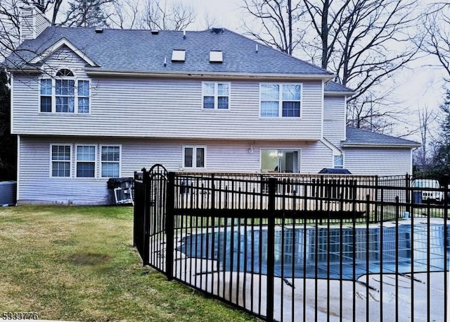 rear view of property featuring a patio, a covered pool, cooling unit, and a yard