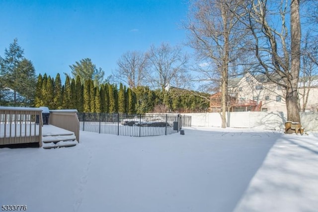 yard layered in snow with a wooden deck